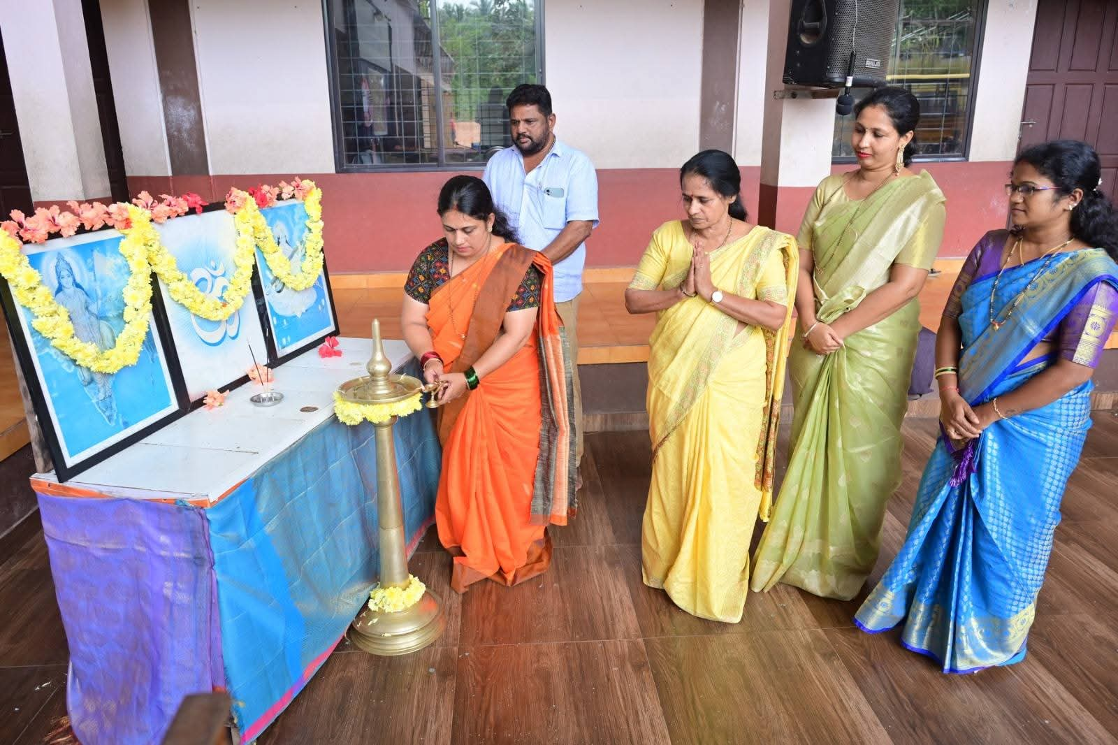 Teachers lighting the ceremonial lamp